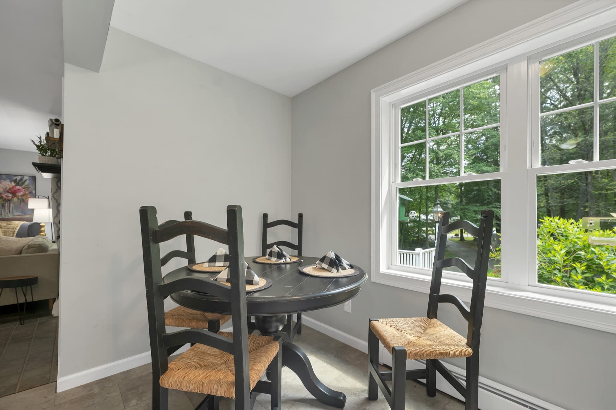 Dining area beside the pellet stove, with woods through the windows