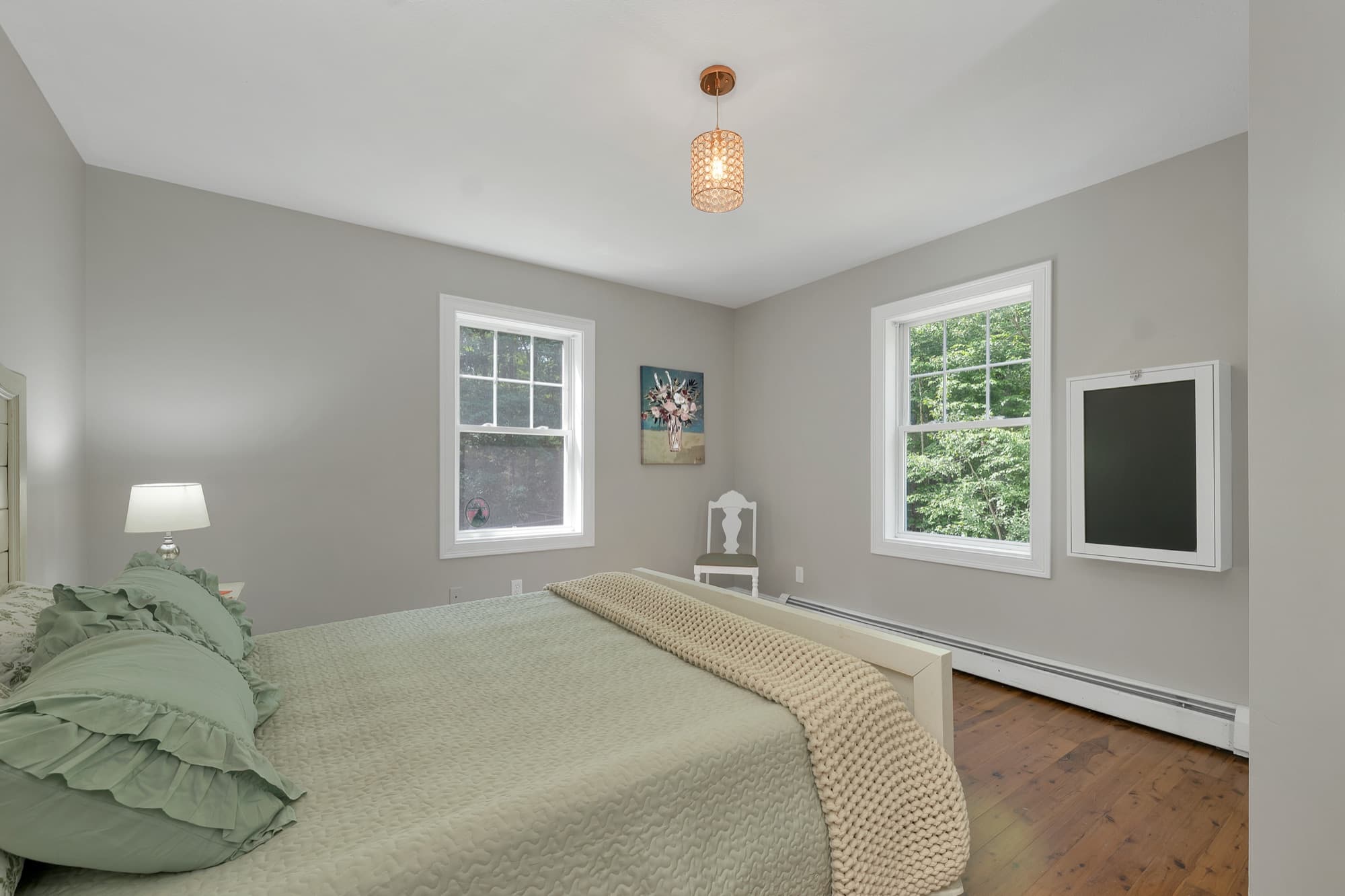 First-floor bedroom with hardwood floors and two windows