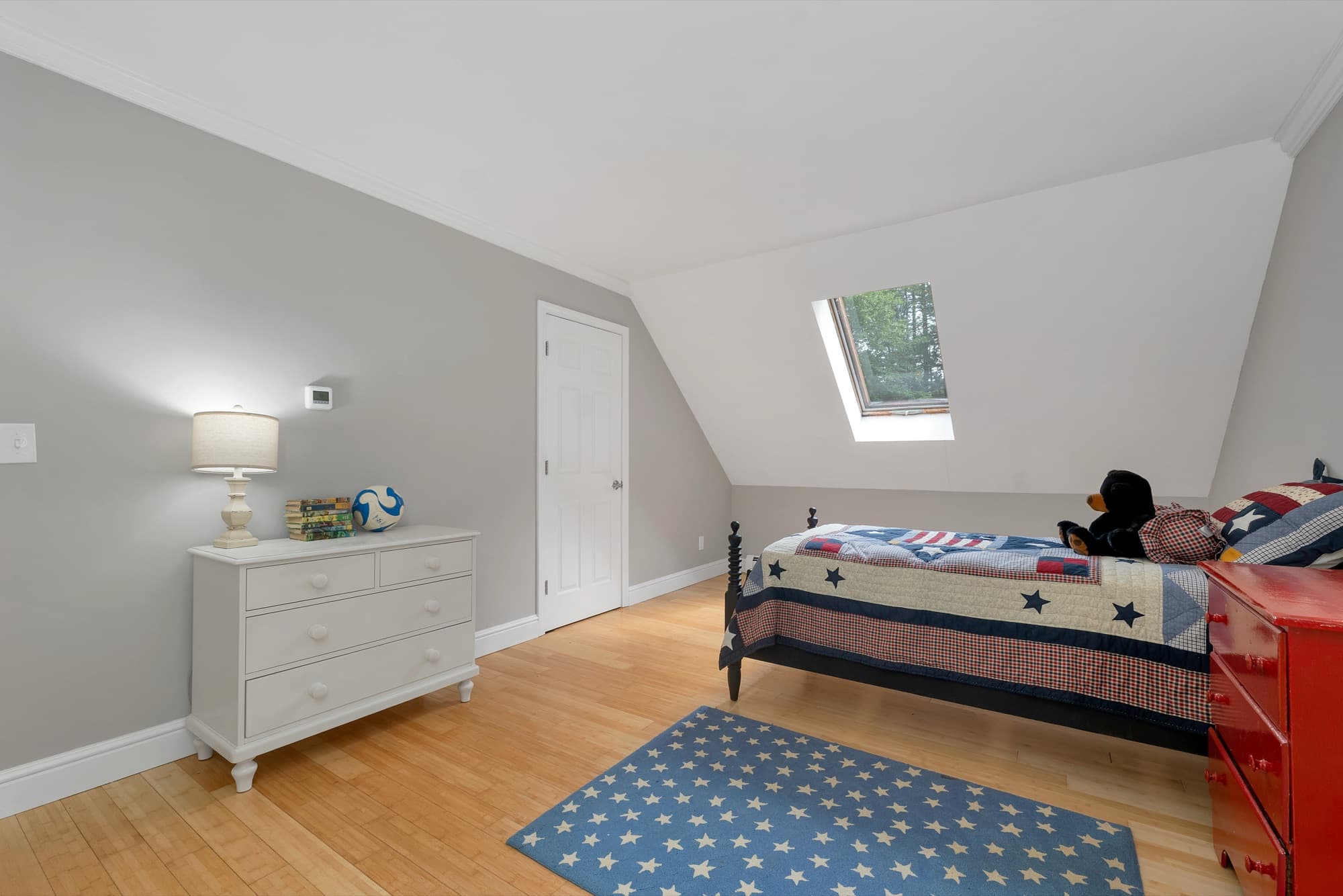 Second-floor bedroom with hardwood and a skylight